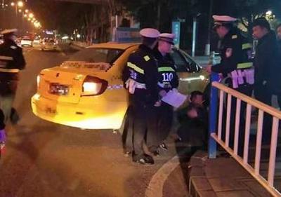 醉酒男子癱坐在地上，民警和駕駛員等待其朋友來(lái)接送。