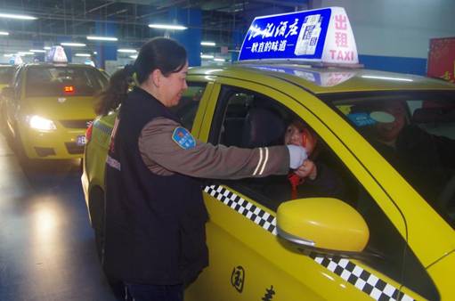 “雷鋒的士”志愿者,送小禮品給歸鄉(xiāng)乘客。